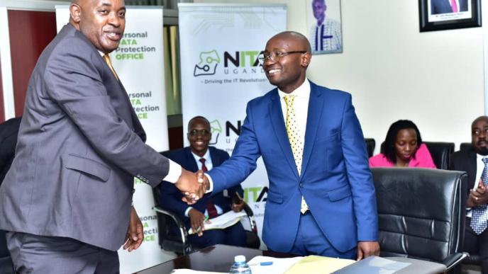 Minister of ICT and National Gudiance, Hon. Chris Baryomunsi (left) congratulating Alexander Kibandama on his appointment as the new Chairperson Board of Directors, NITA-U.