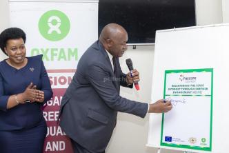 Dr. Chris Baryomunsi, Minister of ICT and National Guidance signs pluck card as a sign for the launch of the ReCIPE Project, an initiative of Oxfam and the Center for Constitutional Governance at Fairway Boutique Hotel in Kampala. PHOTO: PC Tech Magazine