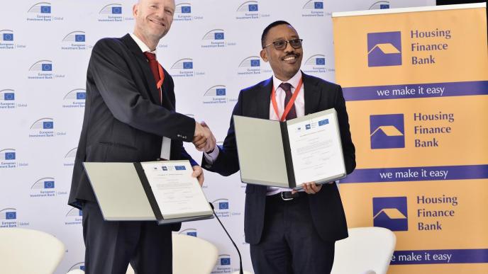 Edward Claessen (left); EIB Head of the Regional Hub for East Africa and Michael Mugabi (right); CEO of Housing Finance Bank shake hands after unveiling a €50 million (UGX212.8 billion) investment partnership. COURTESY PHOTO