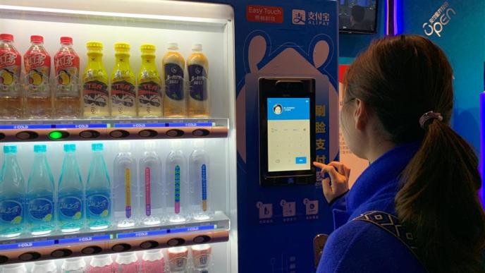 A shopper tries out the facial recognition payment function at a self-service vending machine in Shanghai. (Photo by: Ding Yining / SHINE)