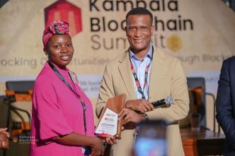 Reginald Tumusiime (right), Chairman of Blockchain Association of Uganda presenting the Excellence in Virtual Assets Research and Policy Framework Award to Sherifah Tumusiime (left), Senior Systems Officer at FIA Uganda. PHOTO: NZE EVE Photography