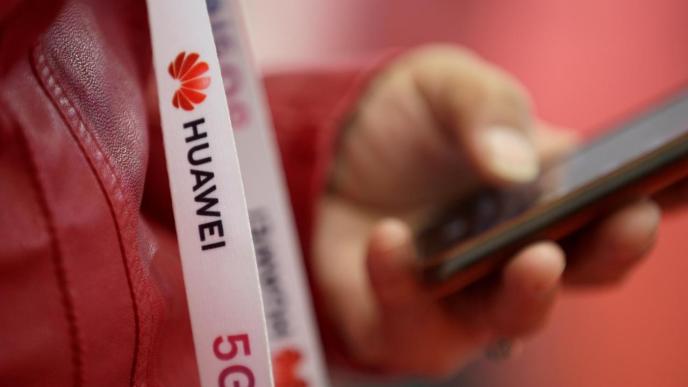 An attendee wears a badge strip with the logo of Huawei and a sign for 5G at the World 5G Exhibition in Beijing, China November 22, 2019. REUTERS/Jason Lee/File Photo UK to use Huawei 5G