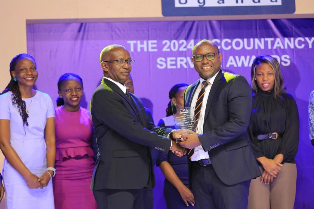 Chairman of the Board of Directors at Eagle Air Ltd, Ben Patrick Kagoro (L), handing over the Finance Team of the Year Accolade to PostBank Uganda’s Chief Finance Officer, CPA Peter Ssenyange (R).