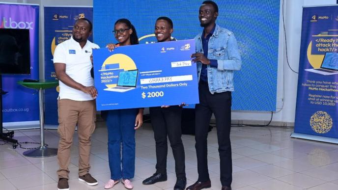 Richard Zulu (extreme left), Co-Founder of OutBox Hub hands over a dummy cheque to the develops of SharePay after securing the 3rd place in the 2023 MTN MoMo Hackathon. COURTESY PHOTO