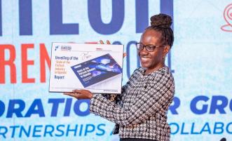 Josephine Olok, FITSPA Uganda board chairperson officially unveiling the 'State of the Fintech Industry in Uganda' report during the 6th annual FITSPA annual fintech conference at the Kampala Sheraton Hotel on Thursday, October 3, 2024. PHOTO: FITSPA