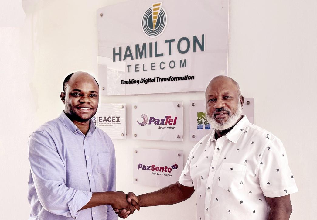 John Paul Ssemyalo (left), CEO of Pebuu Africa and John Kamya (right), the Board Chairman of Hamilton Telecom shake hands after announcing their partnership at a meeting at the Hamilton Telecom offices in Kololo. Courtesy Photo