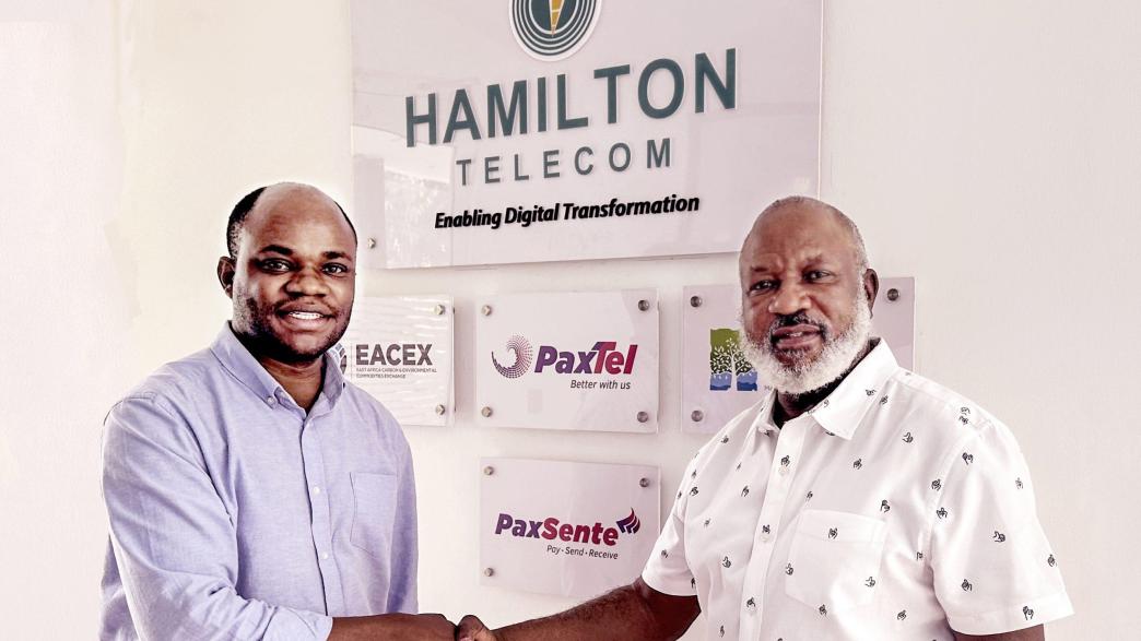 John Paul Ssemyalo (left), CEO of Pebuu Africa and John Kamya (right), the Board Chairman of Hamilton Telecom shake hands after announcing their partnership at a meeting at the Hamilton Telecom offices in Kololo. Courtesy Photo