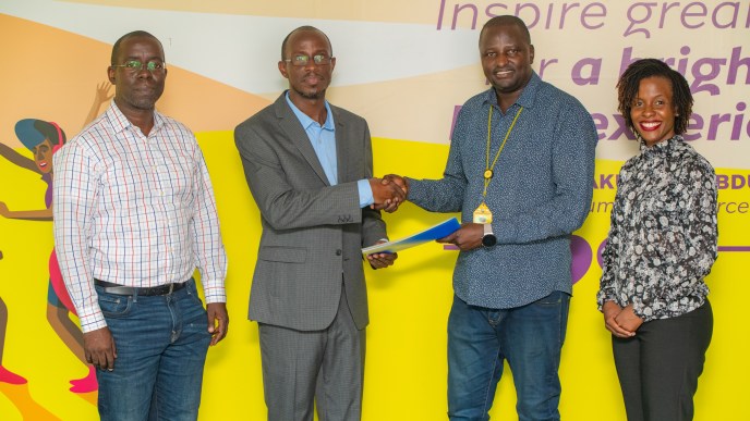 JUMO's Country Manager, Wilfred Wabwire (2L) shakes hands with MTN MoMo Uganda's Managing Director, Richard Yego (3L) upon launching MoSente at the MTN MoMo Uganda Offices in Kololo.