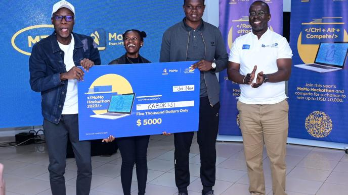 The Kabokisi app developed by a team of three; Paul Barasa Ojiambo, Emmanuel Modi, and Lilian Katsiime pose for a photo with Stephen Mutana (extreme right); MTN MoMo's Chief Strategy & Stakeholder Management officer after they were announced as the overall winners of the 2023 MTN MoMo Hackathon.