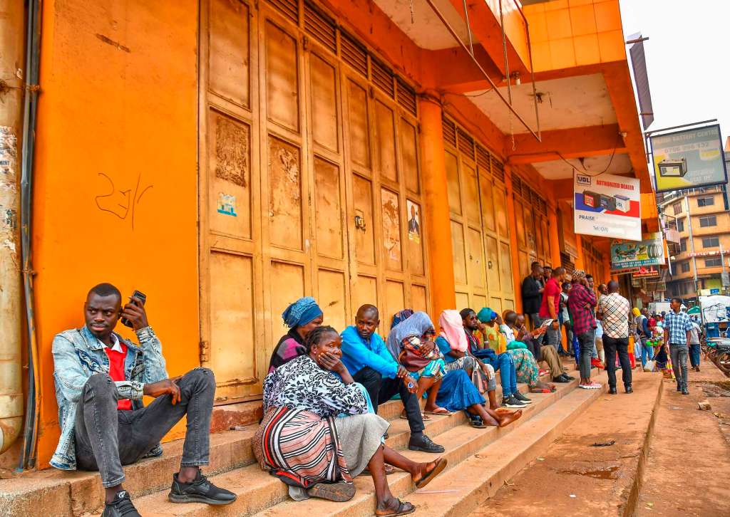 Traders sit outside their closed shops as they demonstrate against the Electronic Fiscal Receipting and Invoicing Solution (EFRIS) in Kampala, Uganda on April 8, 2024. PHOTO | NMG