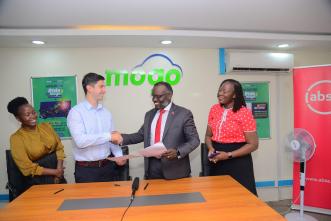 Mogo Uganda CEO Mikhail Vydry (left) and Executive Director and Head of Markets for Absa Bank Uganda, David Wandera (right) shake hands after signing their MoU. Courtesy Photo