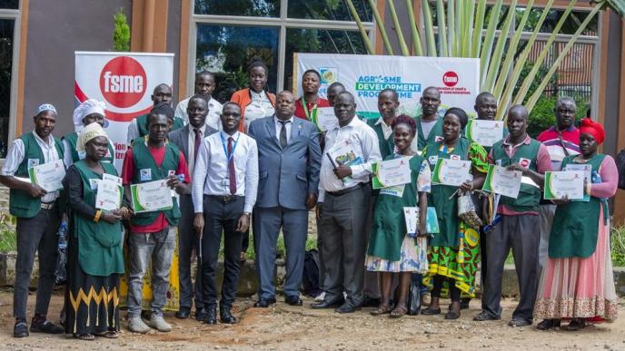 Charles Ichogor; Arua's Resident City Commissioner (4th from left in Grey suit) with representatives from PostBank Uganda and the Federation of Small and Medium Enterprises pose for a group photo with farmers and SMEs after a 4-day training under the PostBank Agri-SME Skills Development Program.