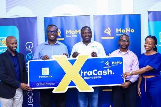 PostBank Uganda and MTN MoMo Uganda officials pose for a group photo after launching, Xtracash, a digital Micro Lending solution that will extend loans to mtn mobile money customers.