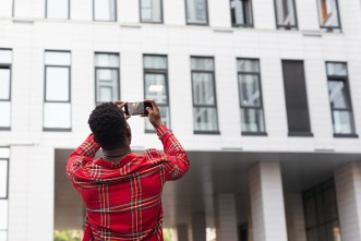 Pictured a young male adult taking pictures of a building. PHOTO: Freepik