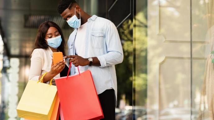 A couple pictured checking their phone after shopping. COURTESY PHOTO