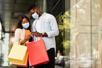 A couple pictured checking their phone after shopping. COURTESY PHOTO