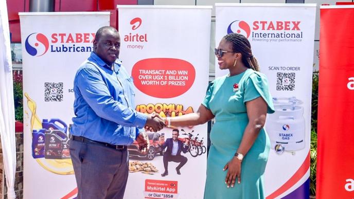 Justus Kiptoo (left), General Manager of Stabex International and Airtel Mobile Commerce Uganda's Head of Operations, Hope Ekudu shake hands after announcing their partnership to boost cashless transactions.