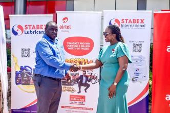 Justus Kiptoo (left), General Manager of Stabex International and Airtel Mobile Commerce Uganda's Head of Operations, Hope Ekudu shake hands after announcing their partnership to boost cashless transactions.