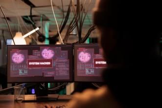 A hacker watches a system hacked alert message appear on a computer screen. PHOTO: DCStudio / via Freepik