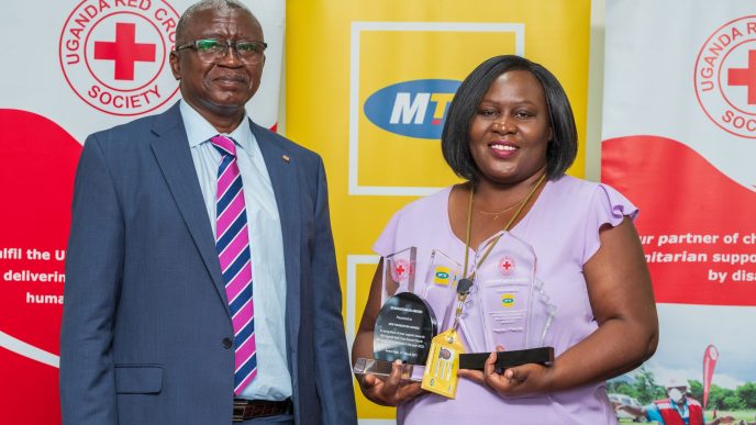 MTN Uganda's General Manager, Ms. Enid Edroma (R) poses with the Humanitarian Award received from the Uganda Red Cross Society Secretary-General, Mr. Robert Kwesiga (L).