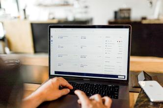 Pictured a person looking at web traffic statistics on a computer. PHOTO: Austin Distel / via Unsplash