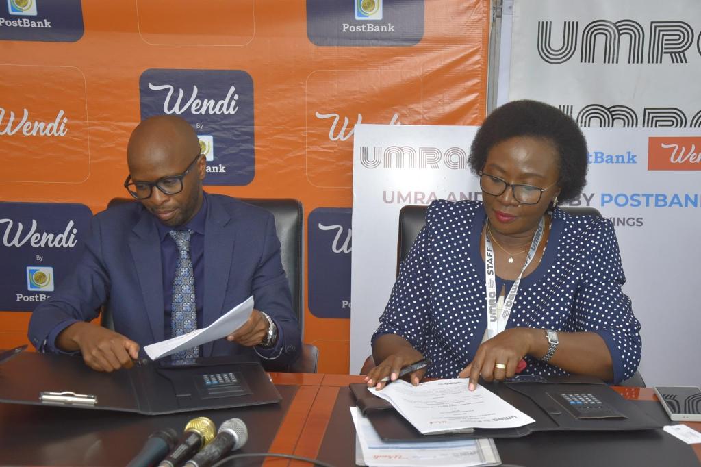 Andrew Kabeera (left); PostBank Uganda Executive Director and Edith Tusuubira (right); Executive Director of UMRA signing an MoU to initiate a collaboration aimed at digitizing the operations of tier IV Microfinance Institutions. Courtesy Photo