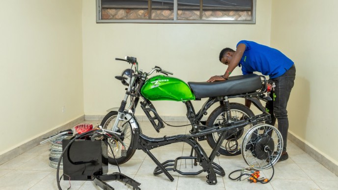 A technician pictured assembling the Zembo e-motorcycle, adding its battery on to it. PHOTO: Zembo